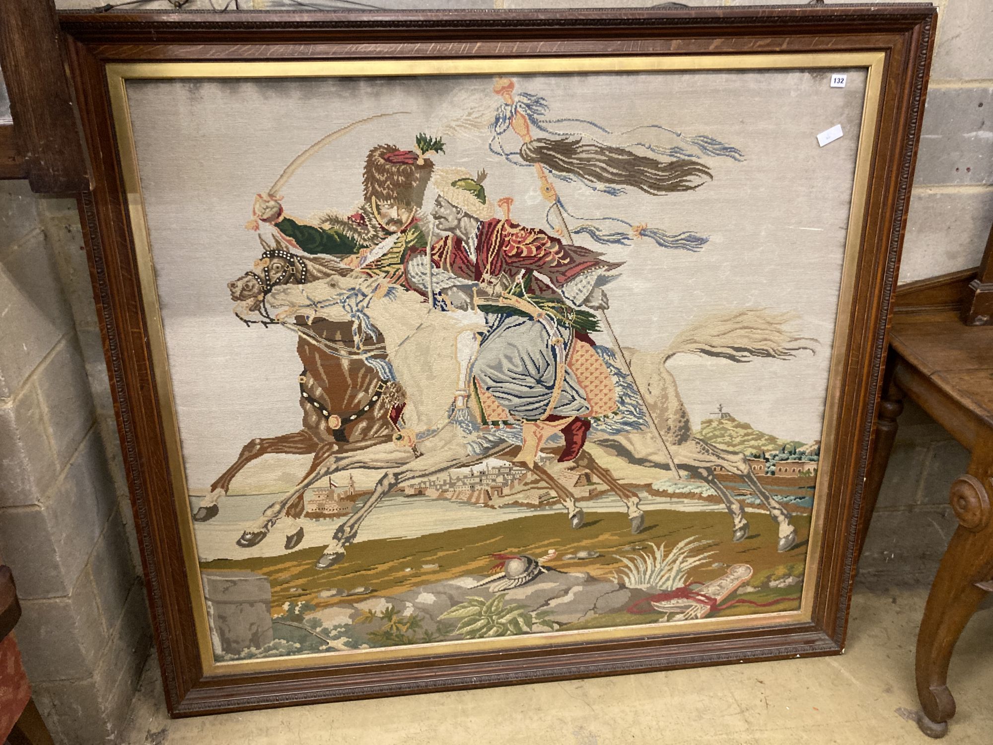A large Victorian polychrome tapestry panel depicting a Hussar mounted and Moor in combat (oak framed), panel 145 x 130cm